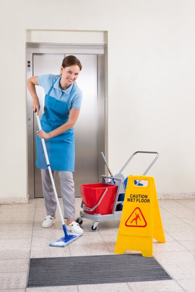 Female Janitor Cleaning a Hallway